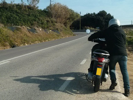 Debido a una avería, este conductor empuja su ciclomotor, ¿circula correctamente?