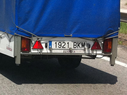 El turismo que conduce lleva enganchado un remolque no ligero, ¿debe llevar iluminadas las placas posteriores de matrícula entre la puesta y la salida del sol?