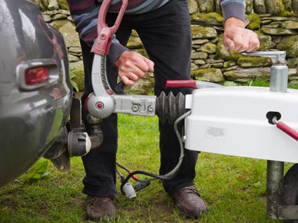 El conductor de la fotografía ha enganchado el remolque a su turismo, ¿qué debe hacer a continuación?
